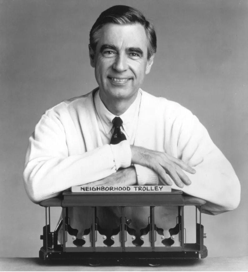 Time Magazine cover photo featuring Mr Rogers leaning over a model trolley.